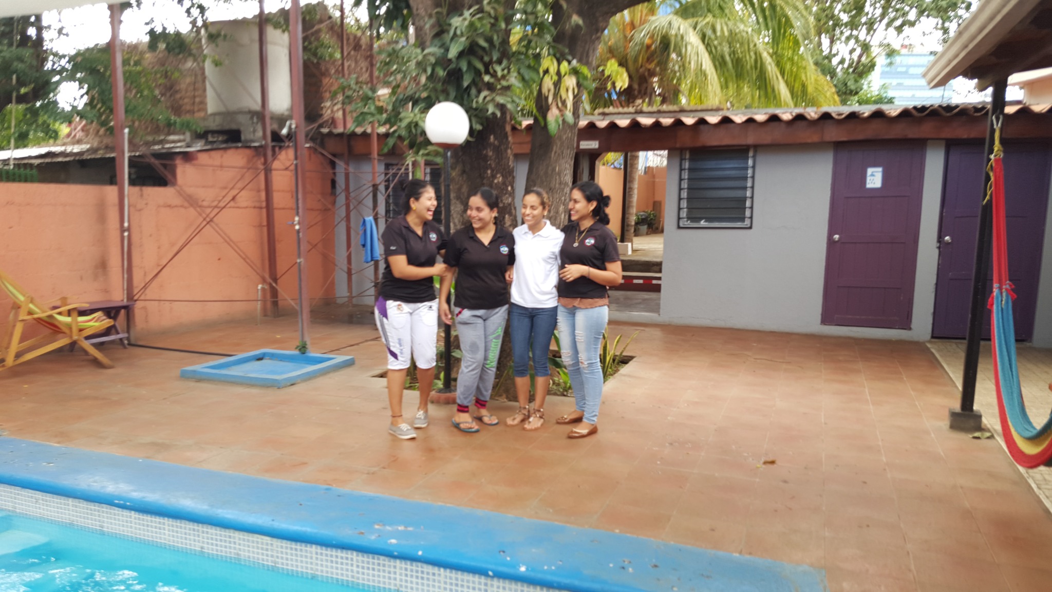 Members of the Managua Backpackers Inn team beside the courtyard pool.